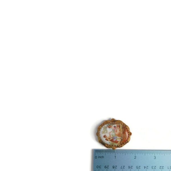 porcelain brooch with ruler for scale