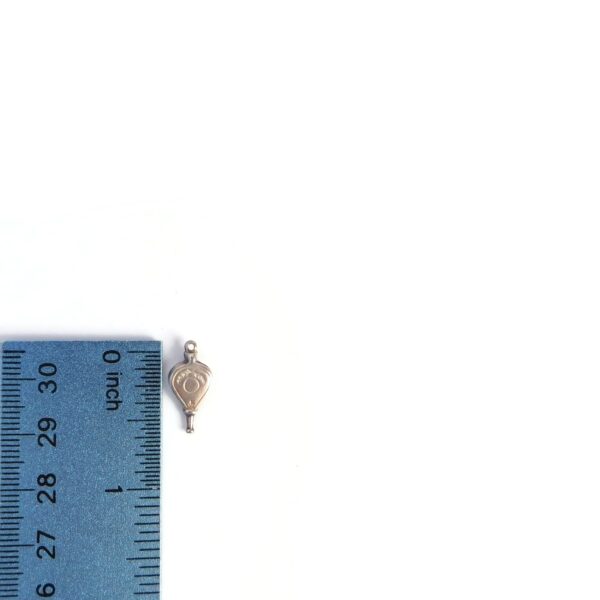 bellows charm with ruler for scale