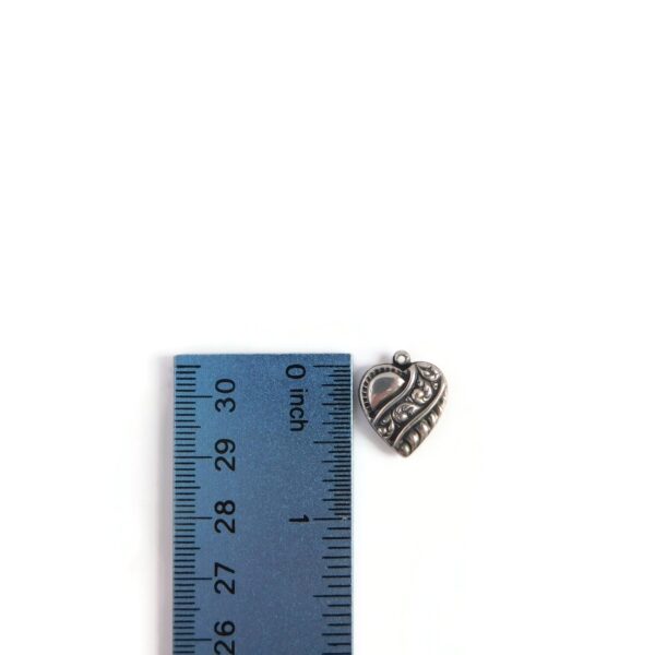 silver puffy heart charm with ruler for scale